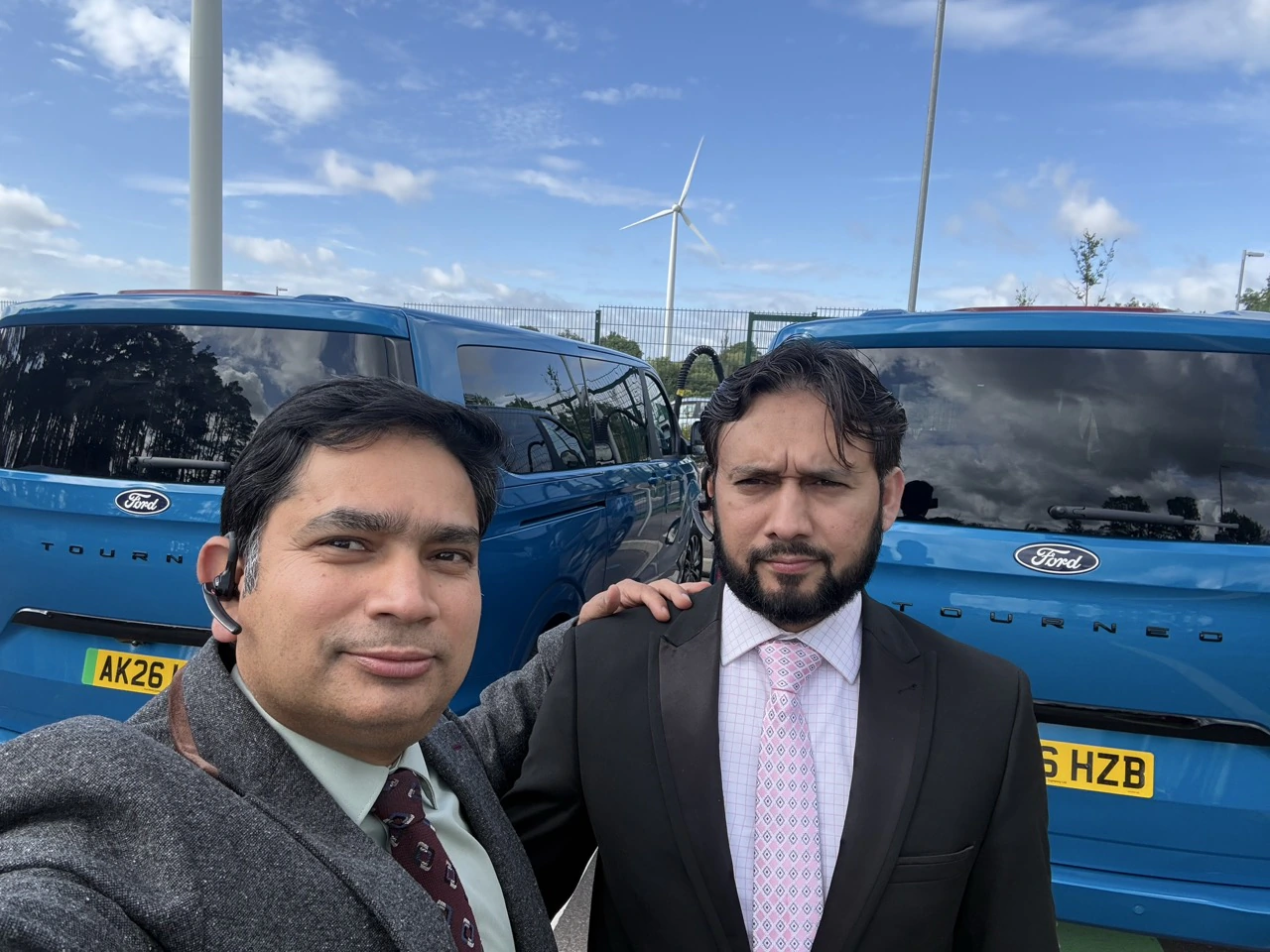Two PTG chauffeurs with blue Ford Tourneo vehicles at a Milton Keynes brand event